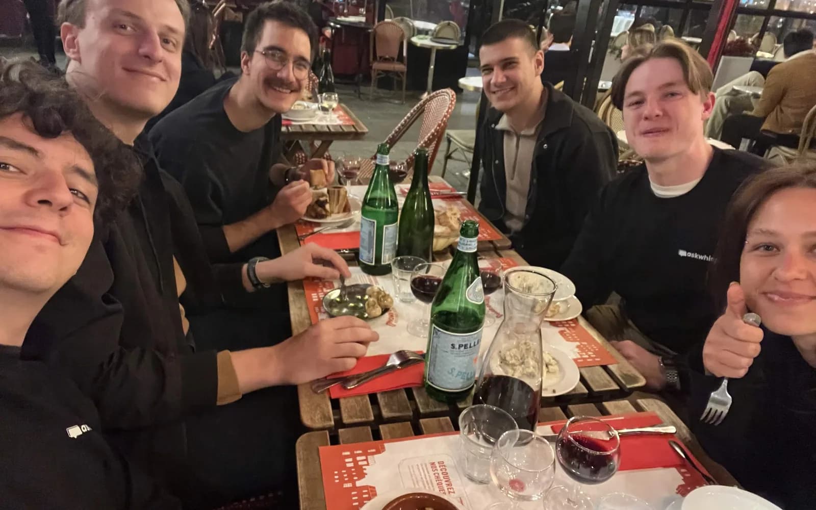 The AskWhisper team round a long table at dinner in Paris